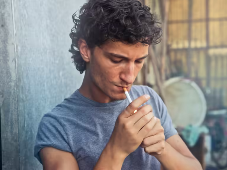 Bărbat care fumează o țigară, simbolizând mitul fumatului ca metodă de relaxare